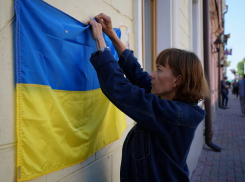 В Одессе женщина сорвала флаг Украины с магазина и бросила его в мусор